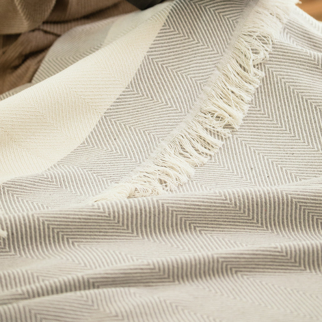 Person reading a book on a textured blanket with a blurred background