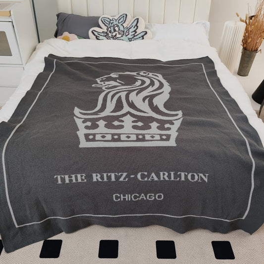 knit blanket with Ritz Carlton logo