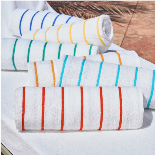 Set of rolled-up towels with colorful stripes on a wooden surface