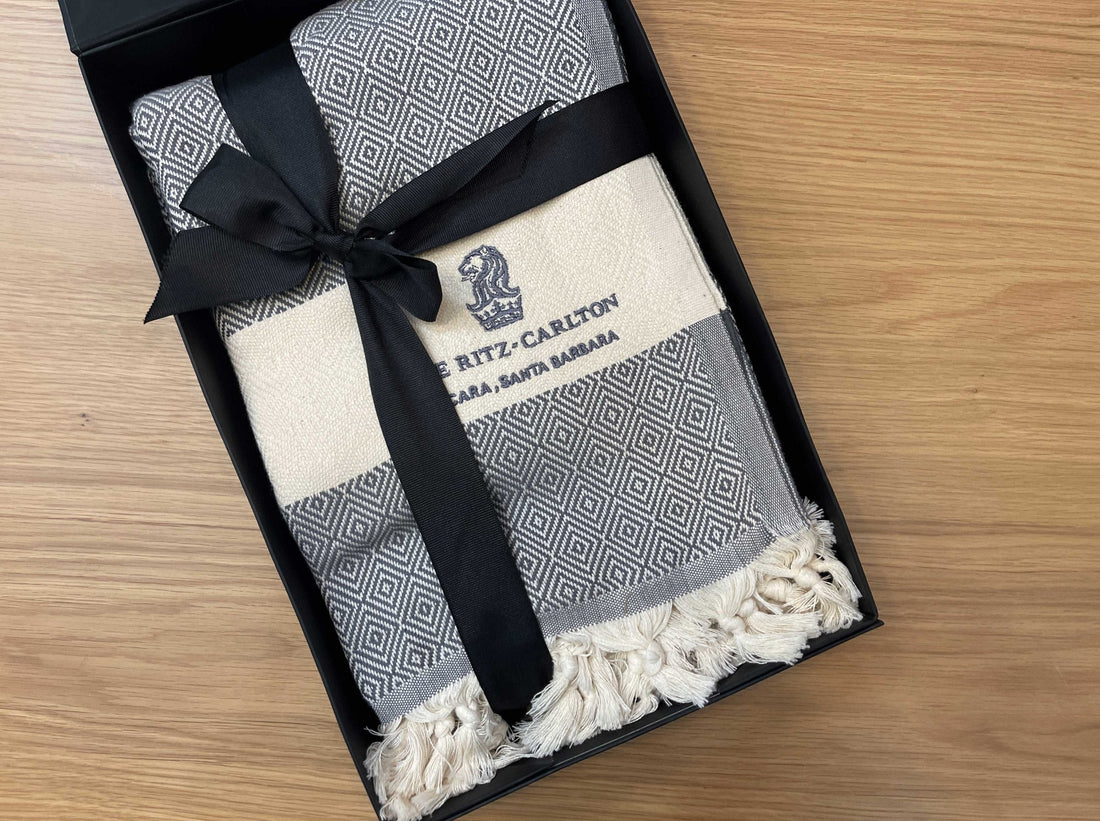 Embroidered Turkish throw tied with black ribbon in a branded gift box