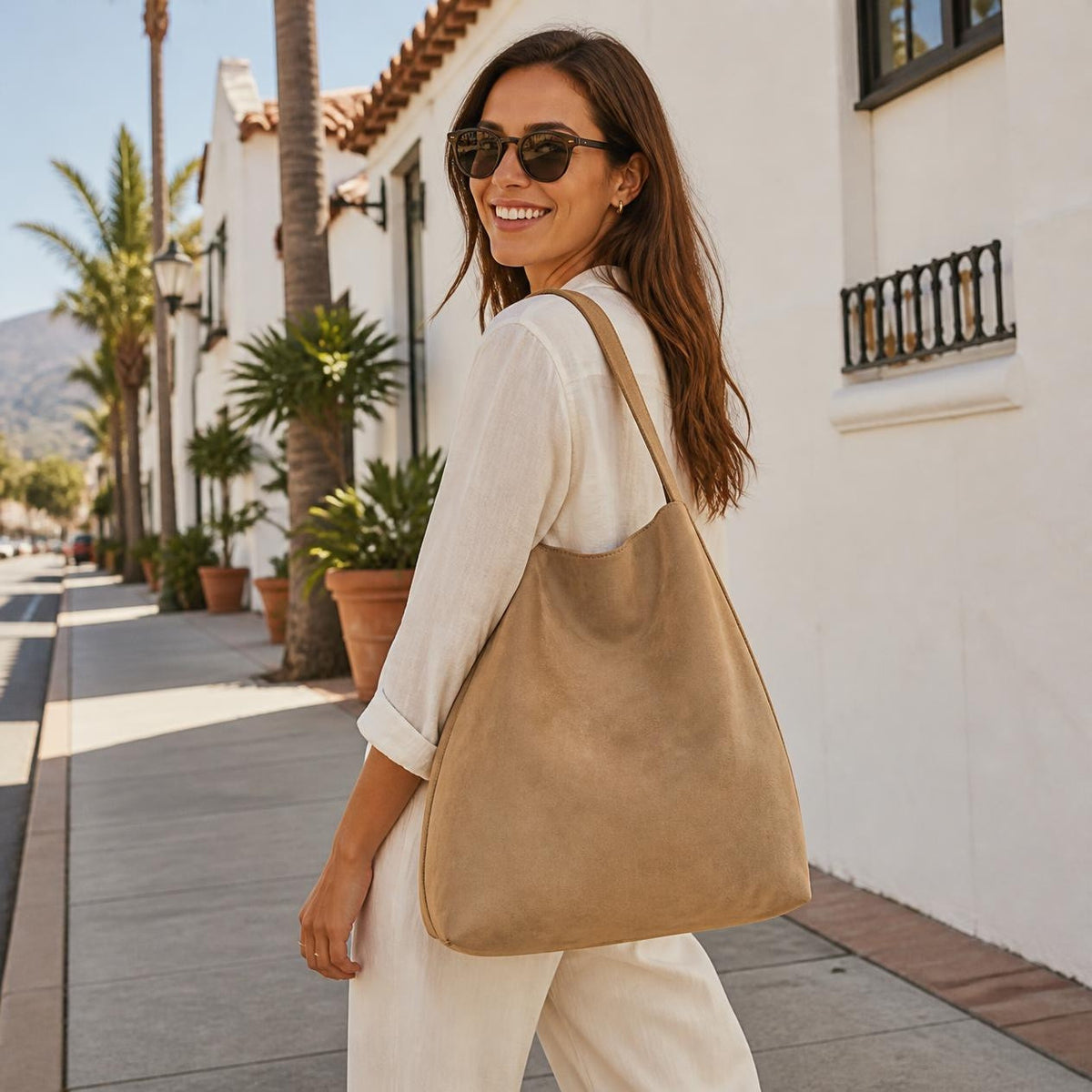 Woman carrying the Sand Marbella suede tote on a Santa Barbara street