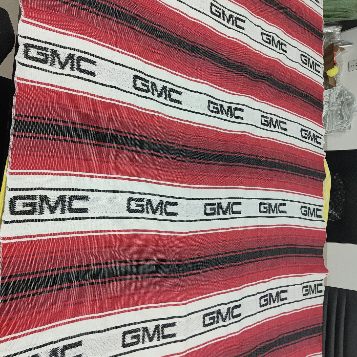 Mexican blanket custom falsa serape Striped fabric with GMC logo pattern on a table