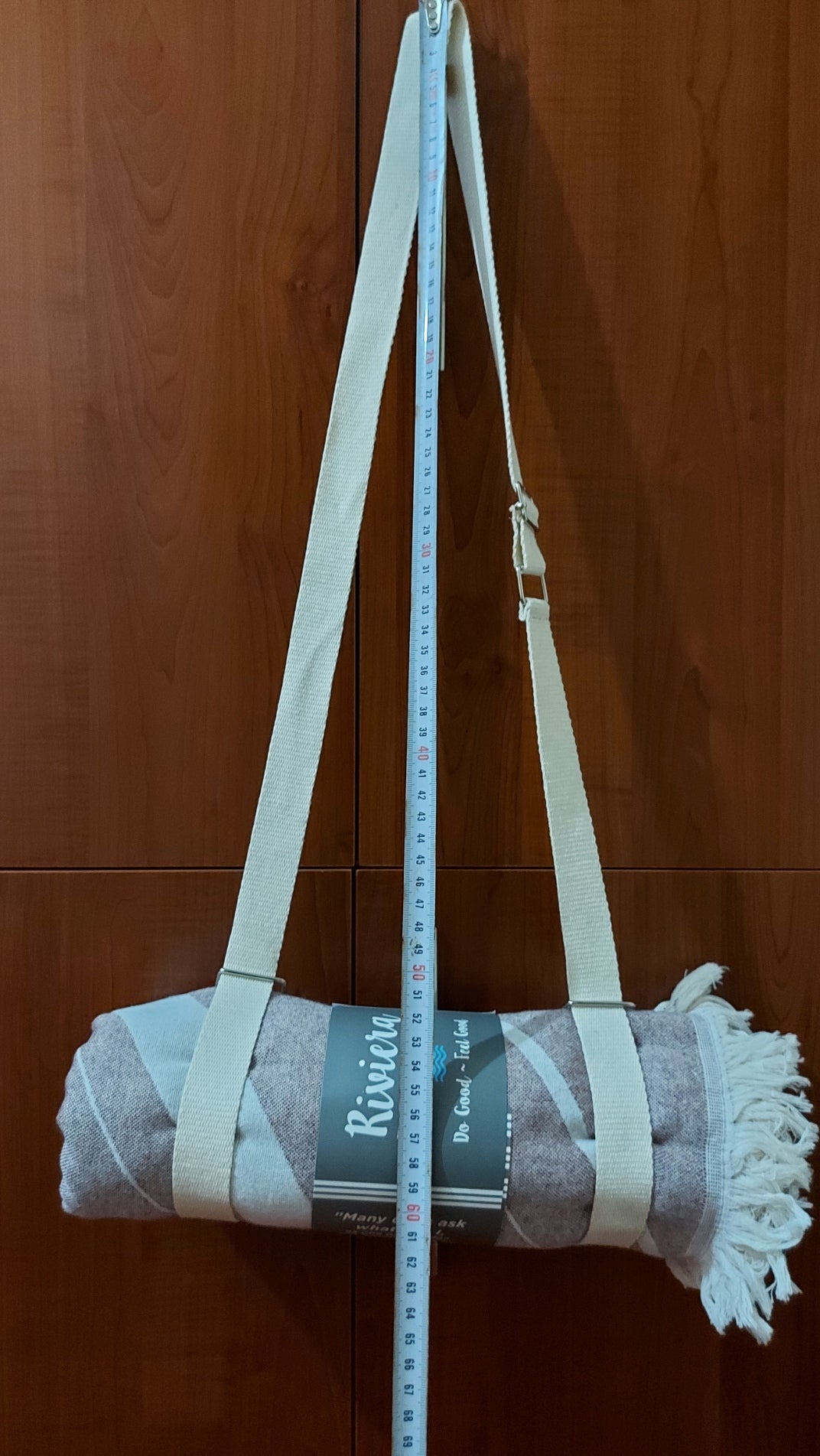 Folded towel with a measuring tape on a wooden floor