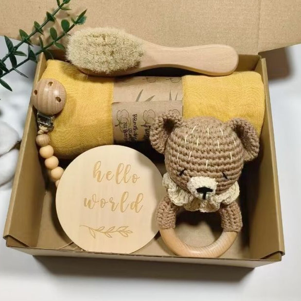 Baby gift set with toys and a blanket in a box on a white background