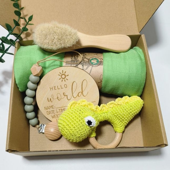 Baby care product set with green items and wooden tools in a box on a white background