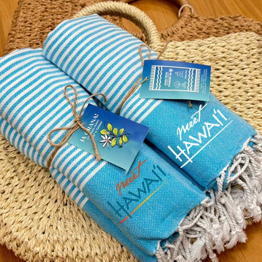 Custom Hang Tags on Blue and white striped towel with 'Made in Turkey' text on a woven mat.