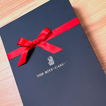 Black gift box with a red ribbon and 'The Ritz-Carlton' logo UV printed. Soft touch gift box with magnetic closure and perfect ribbon.