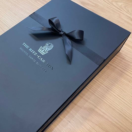 Black gift box with a black ribbon with UV printed logo, for The Ritz-Carlton. With soft touch coating and magnetic closure. 