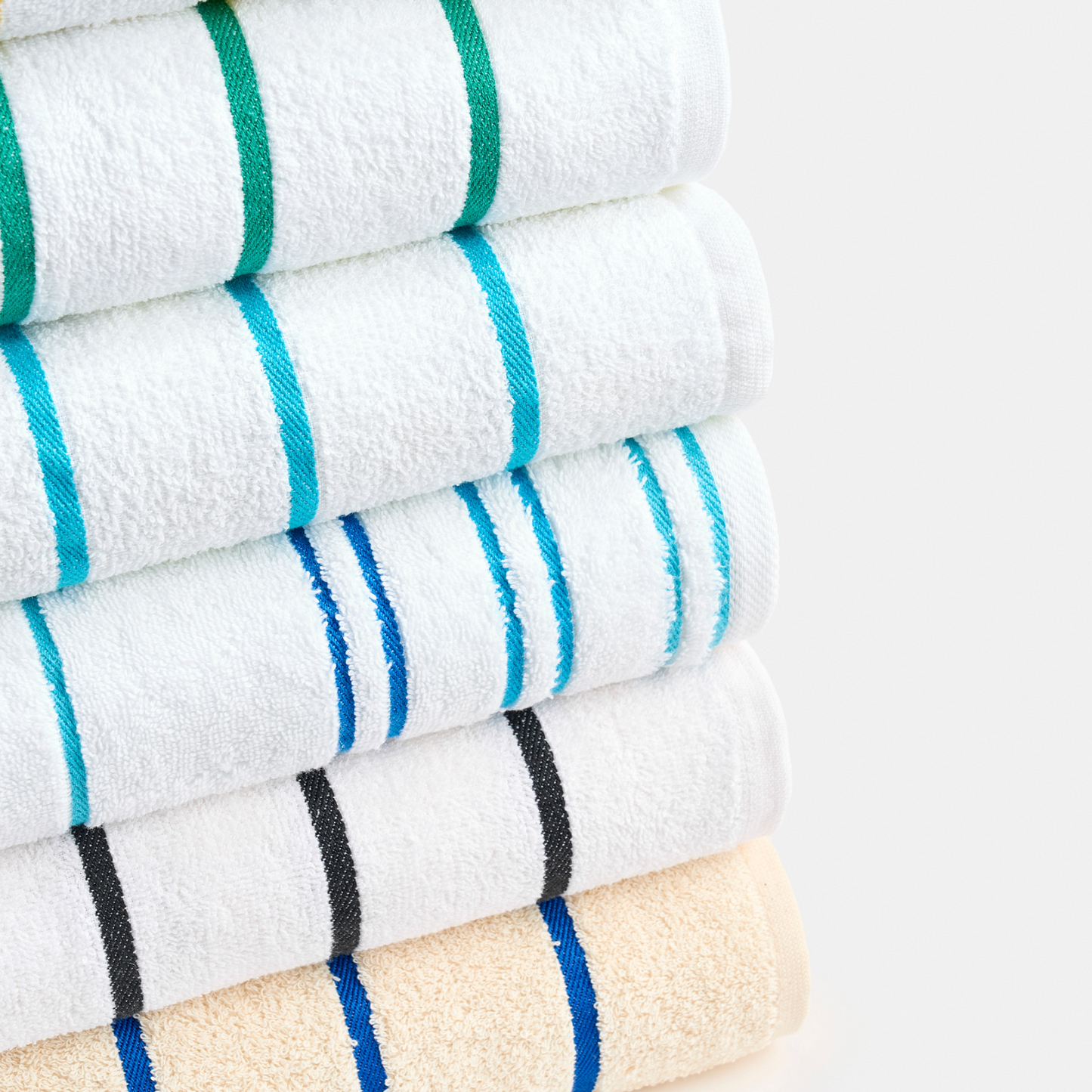 Stack of folded towels with colorful stripes on a light gray background