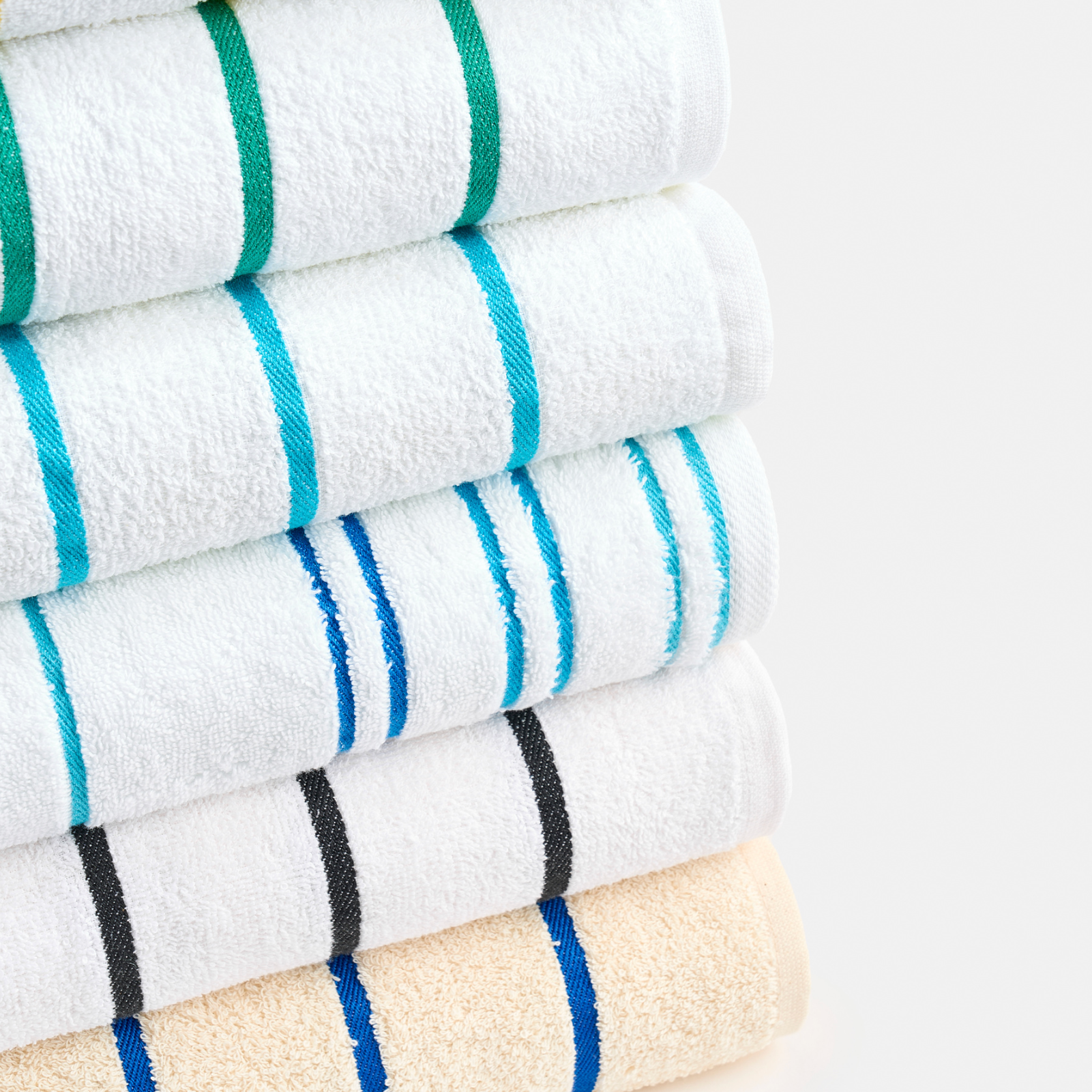 Stack of folded towels with colorful stripes on a light gray background