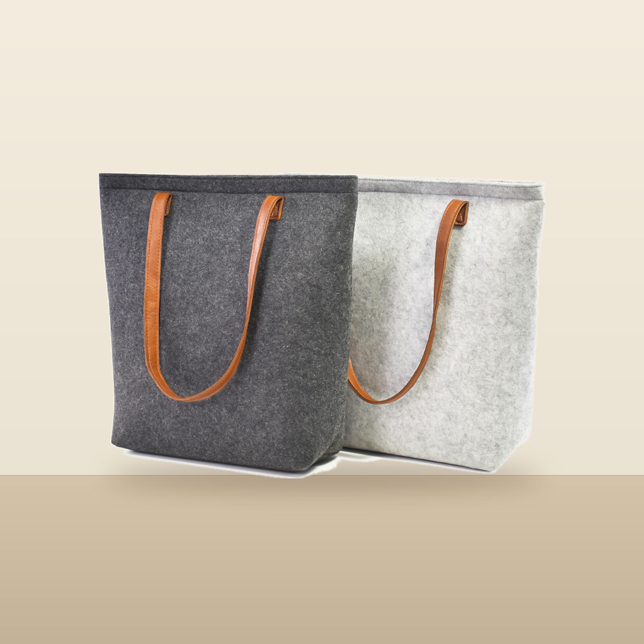 Charcoal and Light Gray Bellagio wool totes on a warm sand backdrop