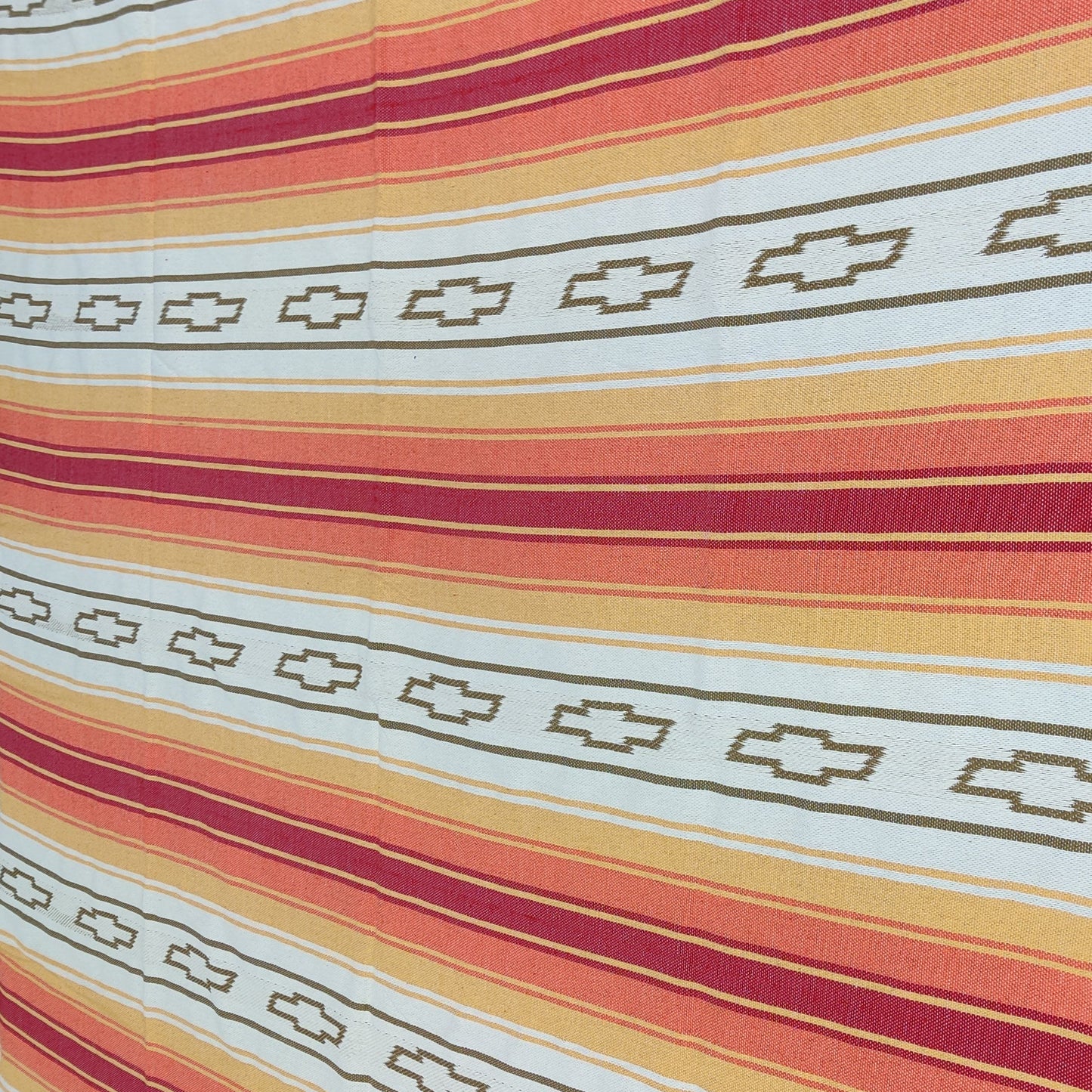 custom woven blanket Mexican serape Striped fabric with red, orange, and white pattern on a flat surface