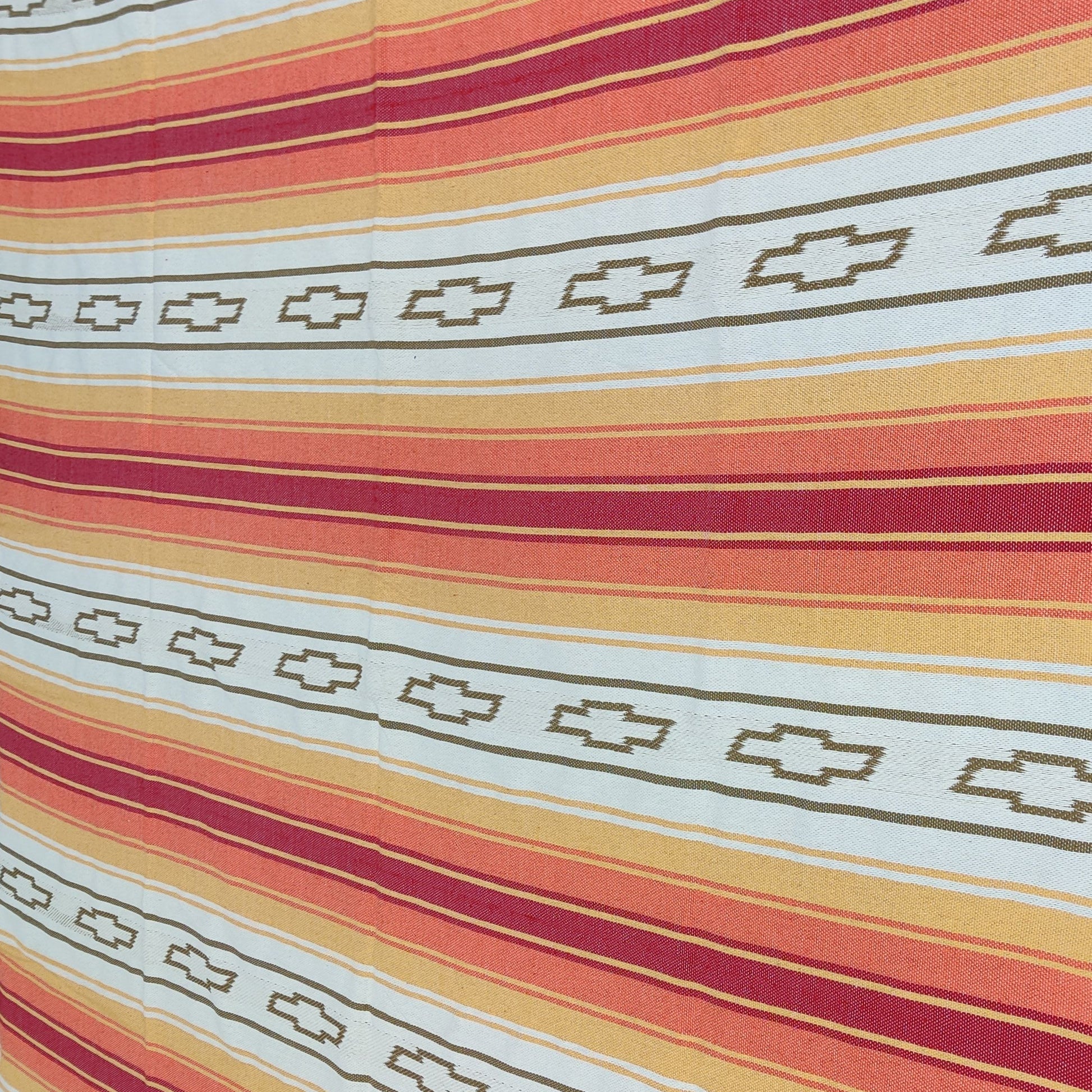 custom woven blanket Mexican serape Striped fabric with red, orange, and white pattern on a flat surface