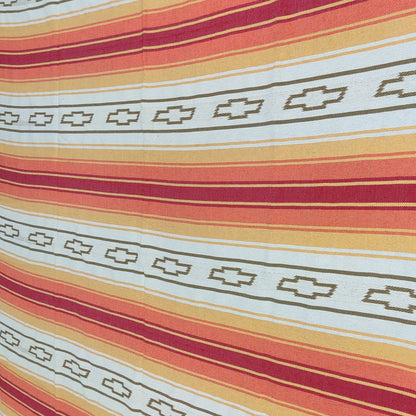 custom woven blanket Mexican serape Striped fabric with red, orange, and white pattern on a flat surface